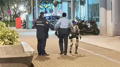 ম্যাকাওয়ে রোবটকে পুলিশ পাহারায় সরিয়ে নেওয়া, বৃদ্ধা আতঙ্কিত